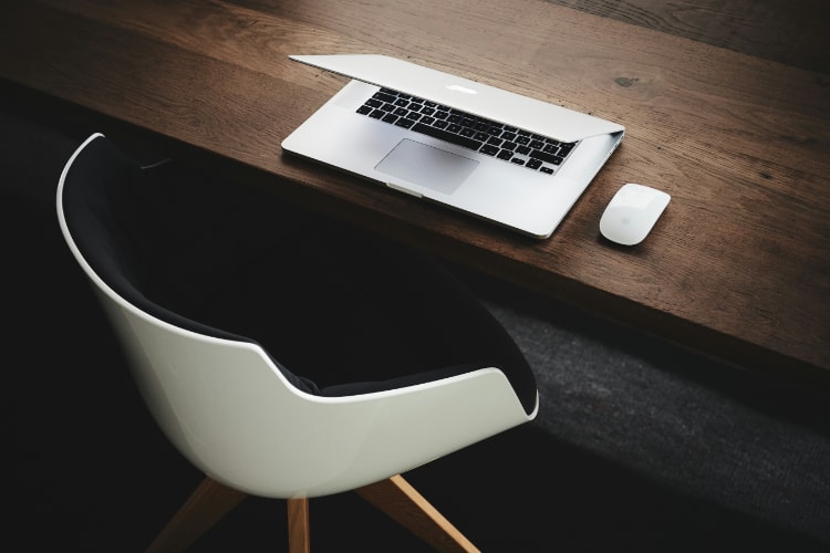 Image of a desk with a chair and an open laptop